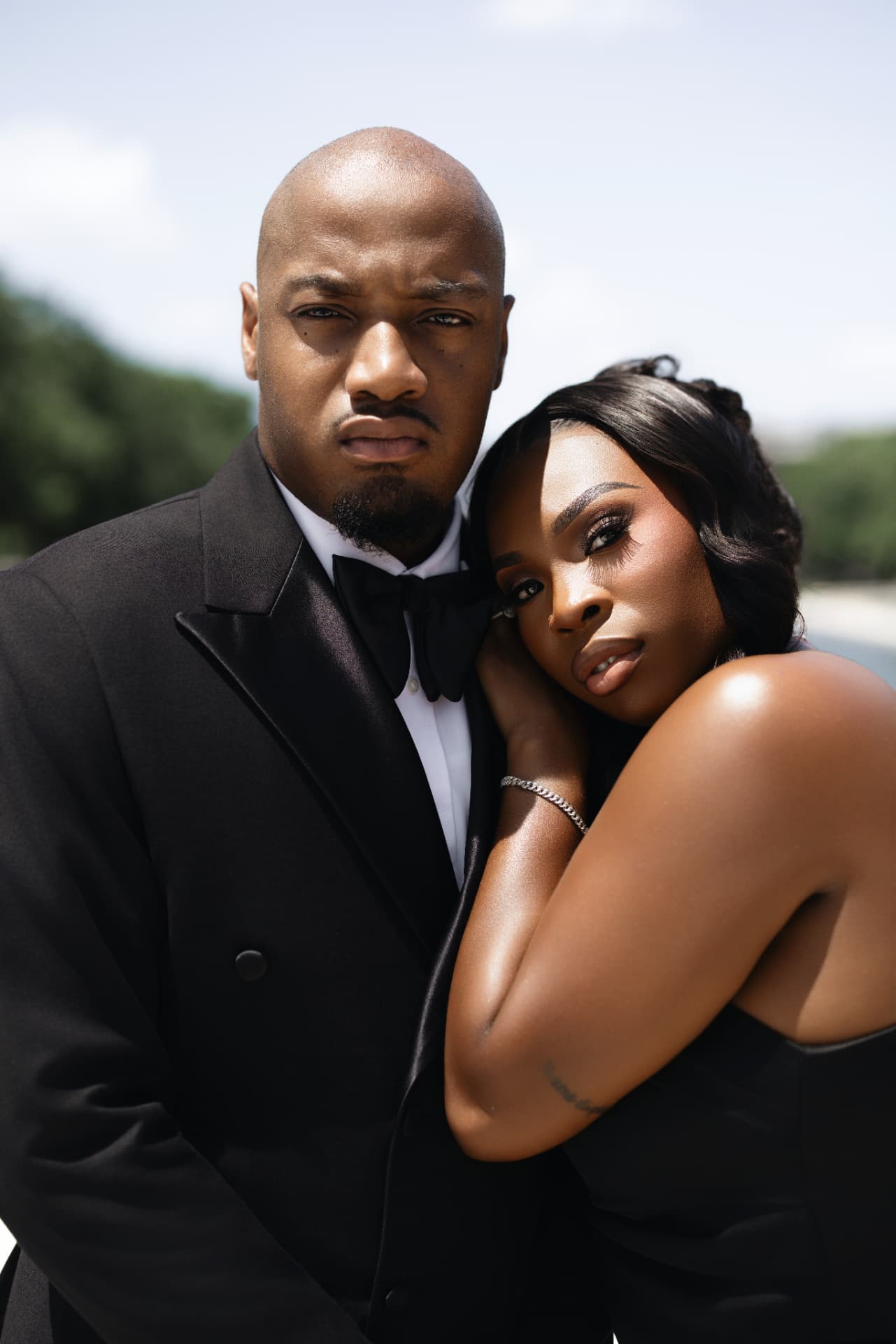 Couple in black tie embracing in bright daylight