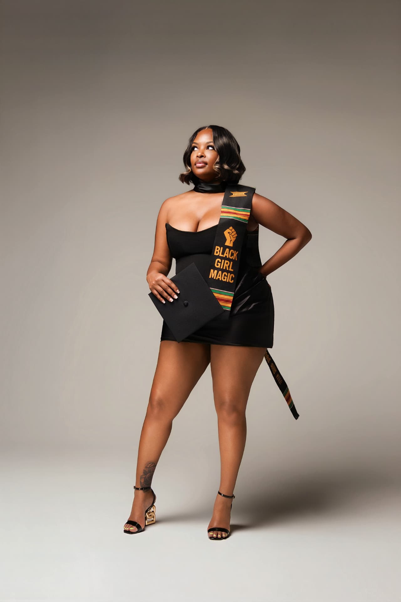 Graduate in a Black Girl Magic stole holding her cap